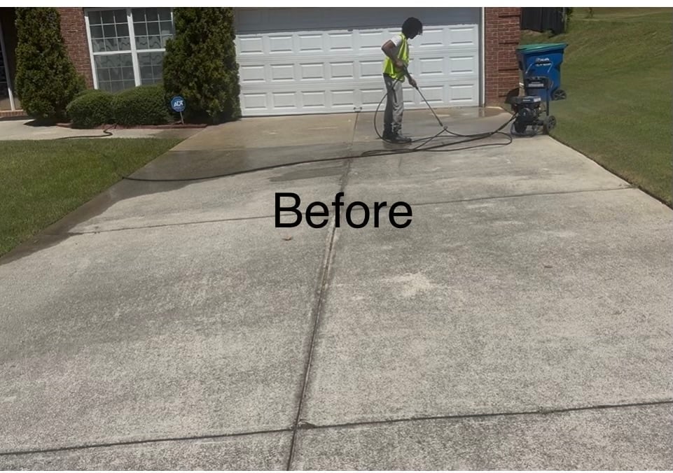 Before shot of a driveway pressure washing job in front of a brick home